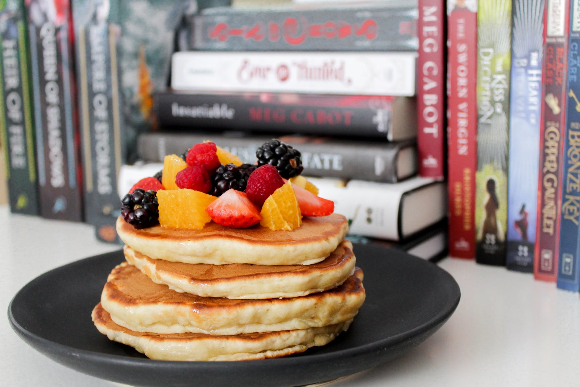 pancake on black plate near books